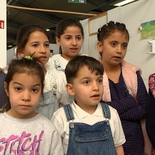 Mehrere Kinder stehen vor der Kamera.