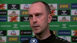 Werder-Trainer Ole Werner steht nach dem Spiel vor einer Werbewand beim Interview.