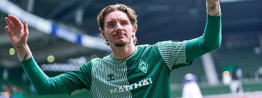Werder-Stürmer Nick Woltemade bedankt sich mit weit ausgebreiteten Armen bei den Fans im Weser-Stadion.