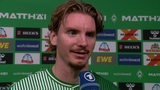 Werder-Stürmer Nick Woltemade nach dem Spiel vor einer Werbewand beim Interview.