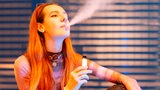 Eine junge Frau raucht eine E-Zigarette.