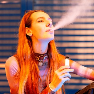 Eine junge Frau raucht eine E-Zigarette.